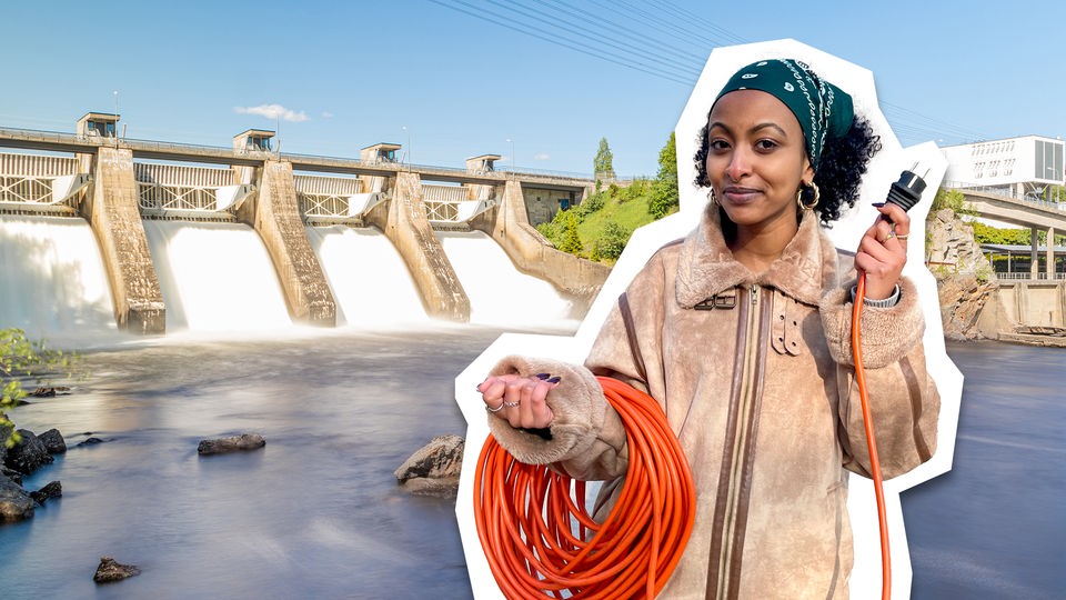 Hinter neuneinhalb-Reporterin Luam ist ein Wasserkraftwerk zu sehen. Luam hält ein Stromkabel in der Hand.