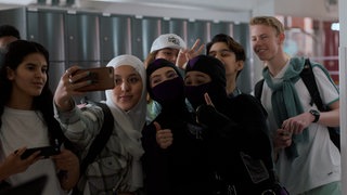 Nach einem erfolgreichen Einsatz posieren die Superninjas Christa und Hunter mit den Schülerinnen und Schülern.