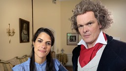 Clarissa steht neben einem Schauspieler, der als Ludwig van Beethoven verkleidet ist.