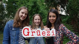 Weltreise Deutschland - Schweiz / Grüezi! (Anna, Louise und Moderatorin Muschda Sherzada, v.l.)