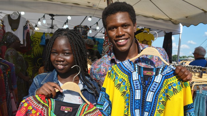 Weltreise Deutschland - Senegal / Fatou zeigt Akeem afrikanische Shirts