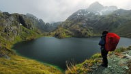 Wanderer am Lake Harris mit Blick auf die Humboldt Mountains in Neuseeland.
