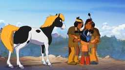 Yakari umarmt zwei erwachsene Indianer.